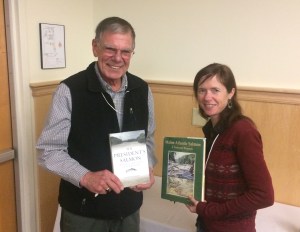 Ed Baum and Catherine Schmitt holding each other's books